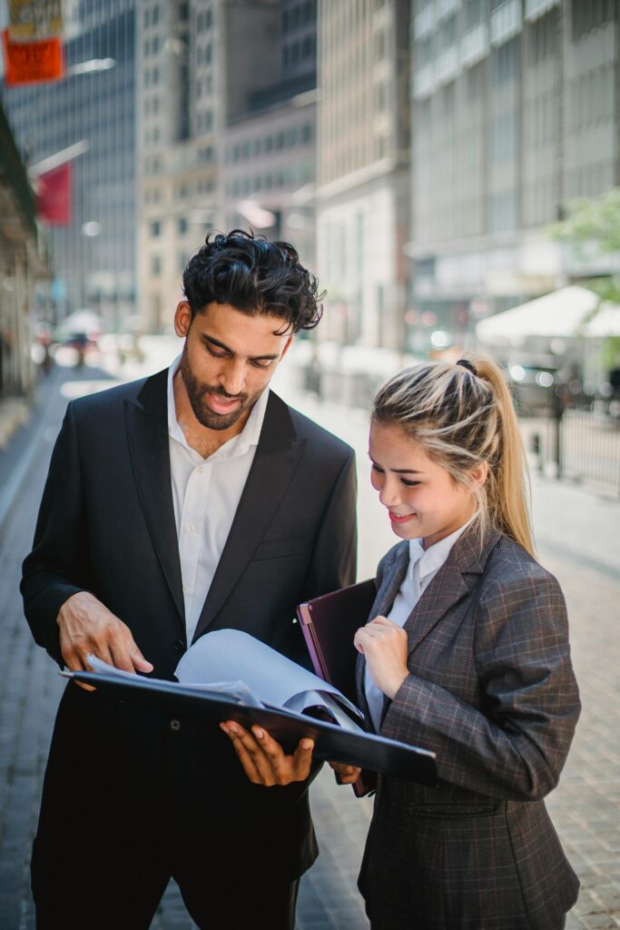 Man Discussing while Holding a Black Document Binder